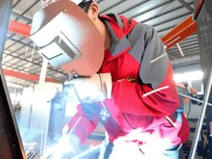 Skilled manual precision welding for critical crane structure joints.